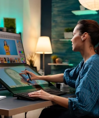 The woman sits in a chair and uses her laptop to project a display of a digital drawing on the screen.