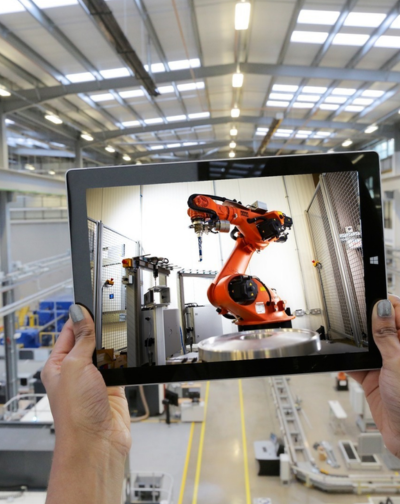 A tablet that someone is carrying displays a robot that stands for industrial video production.