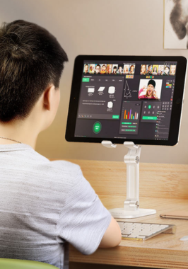 A person sitting at a desk with a computer and keyboard working on social media marketing videos.