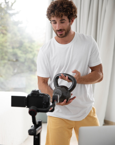 The concept for a promotional film production with a man using an electronic device and a kettlebell