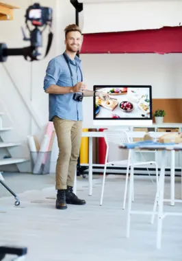 A man is ready to take the best food photography for business purposes as he stands with a camera.