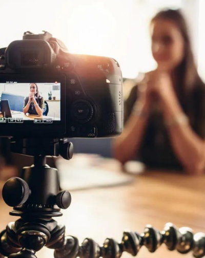 A professional influencer women recording a video on a video camera for social media presence.